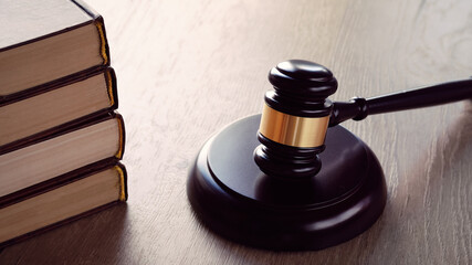 Old white phone and law hammer on wooden table with long shadows. Concept of legal advice,...