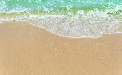 Fototapeta na wymiar Sand beach seaside with white foamy blue wave from the sea