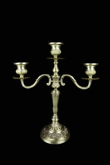 Fototapeta na wymiar Triple bronze vintage candelabrum with three candlesticks on black background