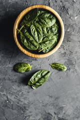 Baby spinach leaves in bowl on grey concrete backgroundClean eating, detox, diet food ingredient