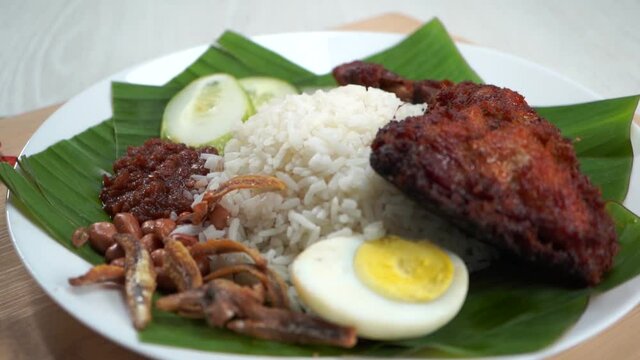 Nasi Lemak dish with chicken drum stick in slow motion