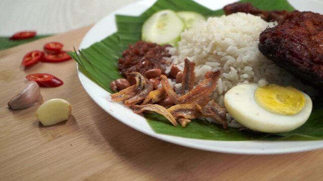 Nasi Lemak dish with chicken drum stick in slow motion