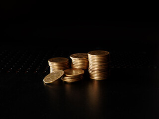 stacks of gold coin on black background concept saving money