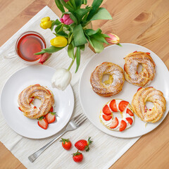 Profiteroles or cream puff cakes with whipped cream and strawberries