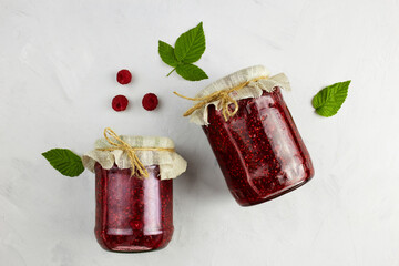 Jars of raspberry jam on light background. Top view. 