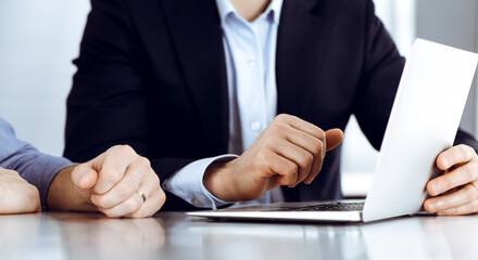 Business people using laptop computer while working together at the desk in modern office. Unknown businessman or male entrepreneur with colleague at workplace. Teamwork and partnership concept
