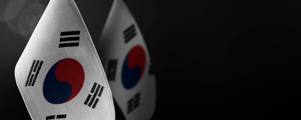 Small national flags of the South Korean on a dark background - obrazy, fototapety, plakaty