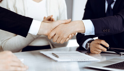 Business people shaking hands after contract signing in modern office. Teamwork, partnership and handshake concept