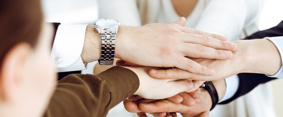 Business people group showing teamwork and joining hands or giving five in modern office. Unknown businessman and women making circle with their hands