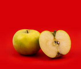 Fresh red apple on red background.