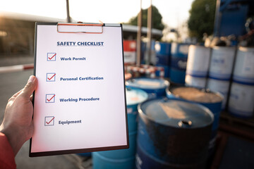 Hand of operation staff is using the safety checklist sheet to verify working condition in chemical...