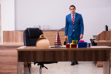 Young male employee celebrating Christmas at workplace