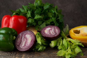 Fresh organic vegetables and herbs on a rustic wooden background