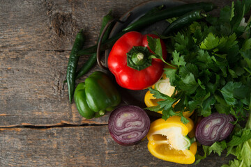 Fresh organic vegetables and herbs on a rustic wooden background