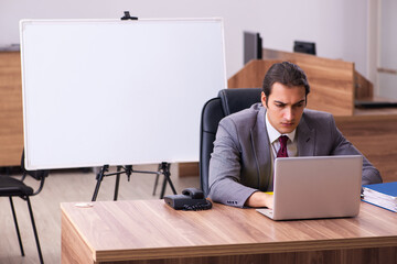 Young male business trainer in the office during pandemic