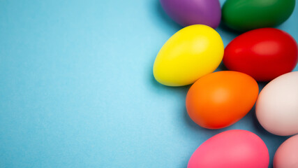 Flat lay set of decorated hand painted chaotically scattered colorful eggs on blue background. Happy Easter concept composition. Image with copy free space for text message
