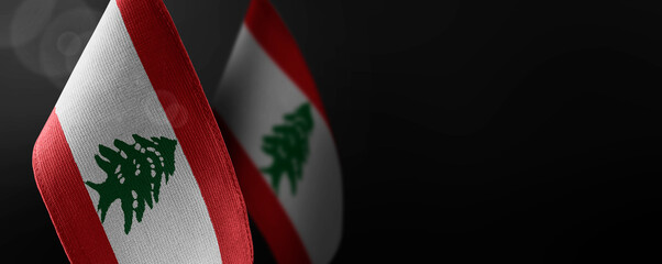 Small national flags of the Lebanon on a dark background