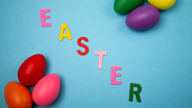 Flat lay set of decorated hand painted chaotically scattered colorful eggs on blue background. Happy Easter concept composition. Image with copy free space for text message letters
