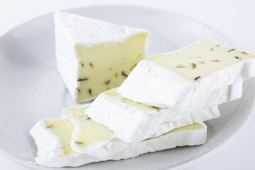 Cheese with white mold sliced on white plate