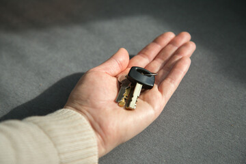 Fototapeta premium Close up shot of keys on a woman's palm. The concept of property, real estate and buying property