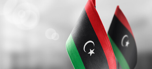 Small national flags of the Libya on a light blurry background
