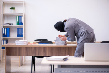 Young male employee in industrial espionage concept