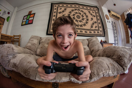 Ni&ntilde;o juega con joystick divertido mirando de frente a la camara