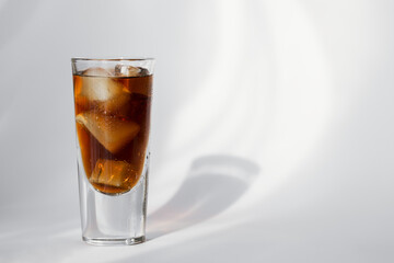 Glass of cola with ice on a white background