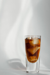 Glass of cola with ice on a white background
