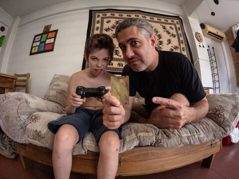 Ni&ntilde;o juega a consola de juegos el padre paga con tarjeta de cr&eacute;dito
