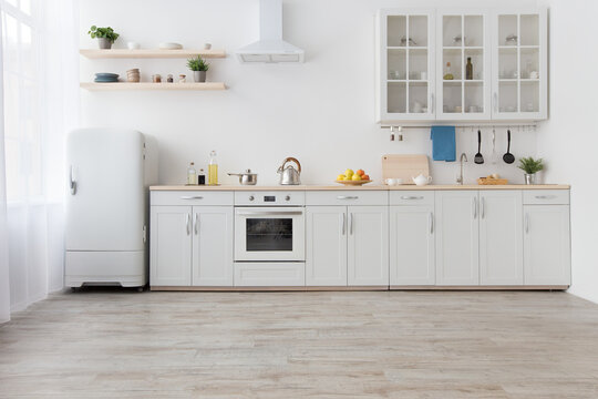 White scandinavian kitchen interior with dining room and wooden floor