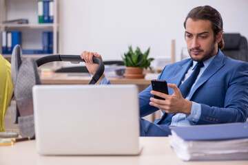 Young male employee looking after new born at workplace