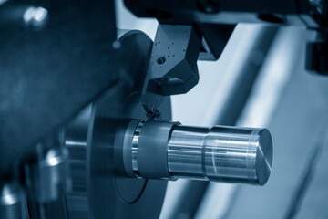 Fototapeta na wymiar The CNC lathe machine cutting the metal shaft parts. The hi-technology metal working processing by CNC turning machine .