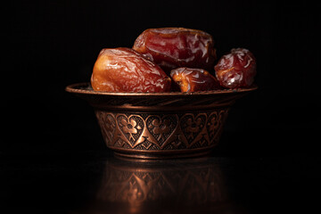 Ramadan concept with dried of dates on black background.