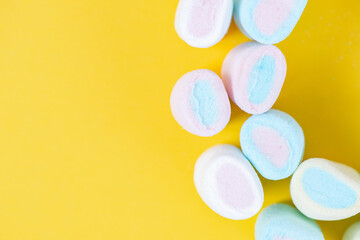 Multicolored sweet soft marshmallow close-up on a yellow background. Festive texture