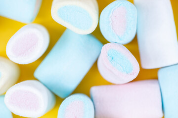 Multicolored sweet soft marshmallow close-up on a yellow background. Festive texture