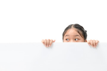 Young girl with beautiful eyes peeking over white corrugated plastic board,
