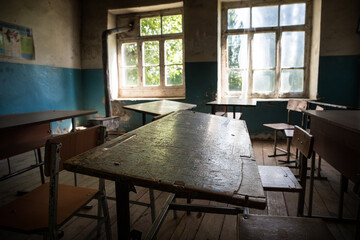 Old and abandoned school classroom interior, in black and white.