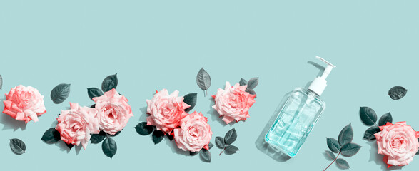 Sanitizer bottle with pink roses overhead view - flat lay