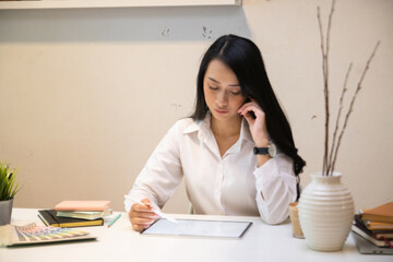 Cropped shot of two UI developers meeting on their project with paperwork and tablet on meeting...