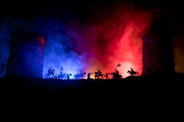 Obraz na płótnie Canvas Medieval battle scene. Silhouettes of figures as separate objects, fight between warriors at night. Creative artwork decoration. Foggy background.