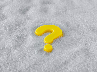 The question mark is yellow. Close-up. White granulated sugar background. Top view.