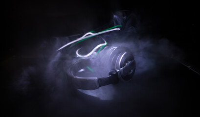 Dj music club concept. Close up headphones on dark background with colorful light.