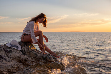 Fototapeta na wymiar Beautiful woman enjoying sunset on the beach.