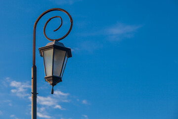 Fototapeta na wymiar Antique style lampposts against a bright blue sky