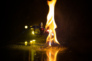 Creative concept. Silhouette of gasoline pistol miniature on dark toned foggy background. Close up....