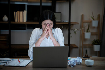 Tired and sleepy woman working in front of laptop till late in office.