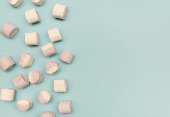 Sweet marshmallow lies on a blue background. Place for text.