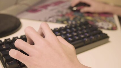 close up of hands playing computer games. Professional eSports Gamer kid Plays Fortnite Game with Super Action and Fun Special Effects on His Personal Computer.