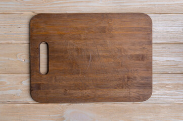 cutting board on beige wooden background, top view